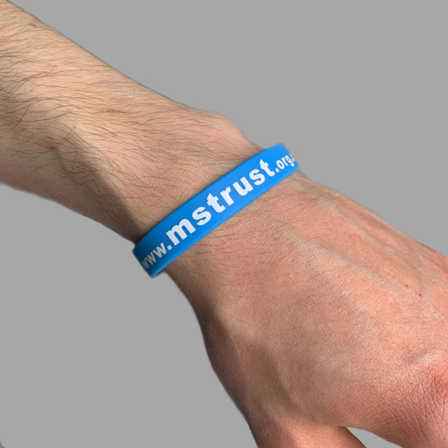 Blue MS Trust wristband on a male's wrist
